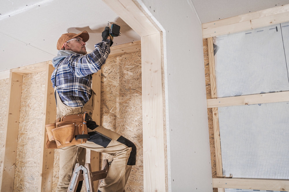 Home restoration in Rhode Island showing exposed framing and licensed contractors at work